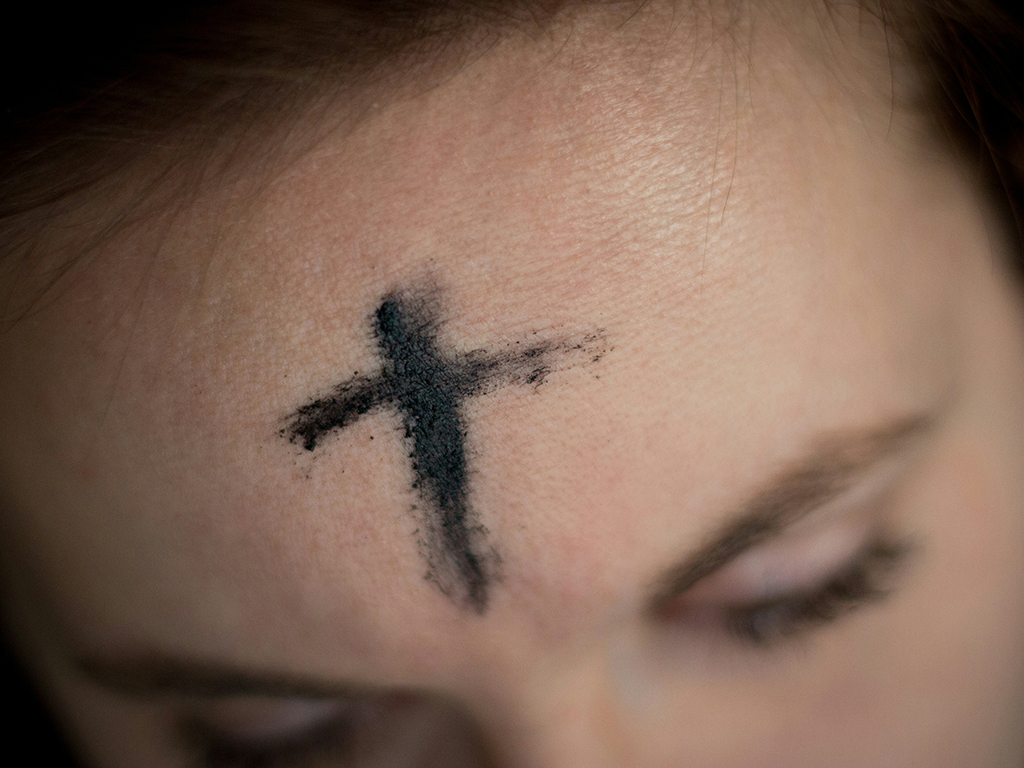 Faithful Reflection: Woman Embracing the Ash Cross on Ash Wednesday