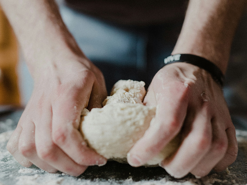 Man kneading dough to make bread during Lent